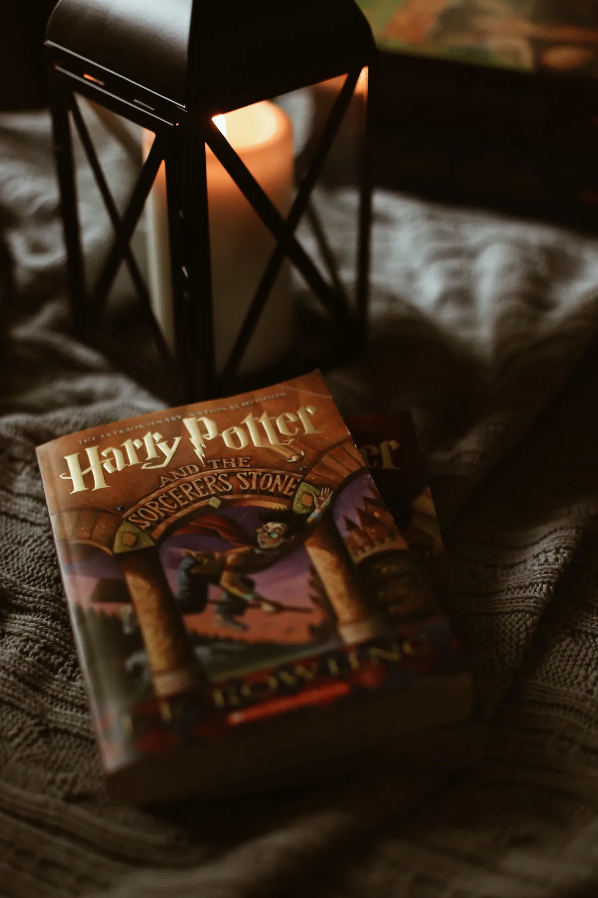 Kerze, Harry Potter Buch auf einer Decke, gemütliche Stimmung